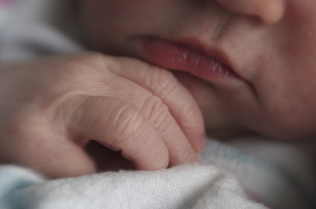 Close up of a baby's hand and lips